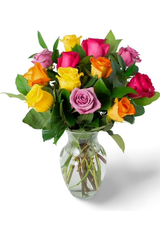 Bouquet of 12 mixed roses in a glass vase with pink, yellow, orange, and lavender blooms.