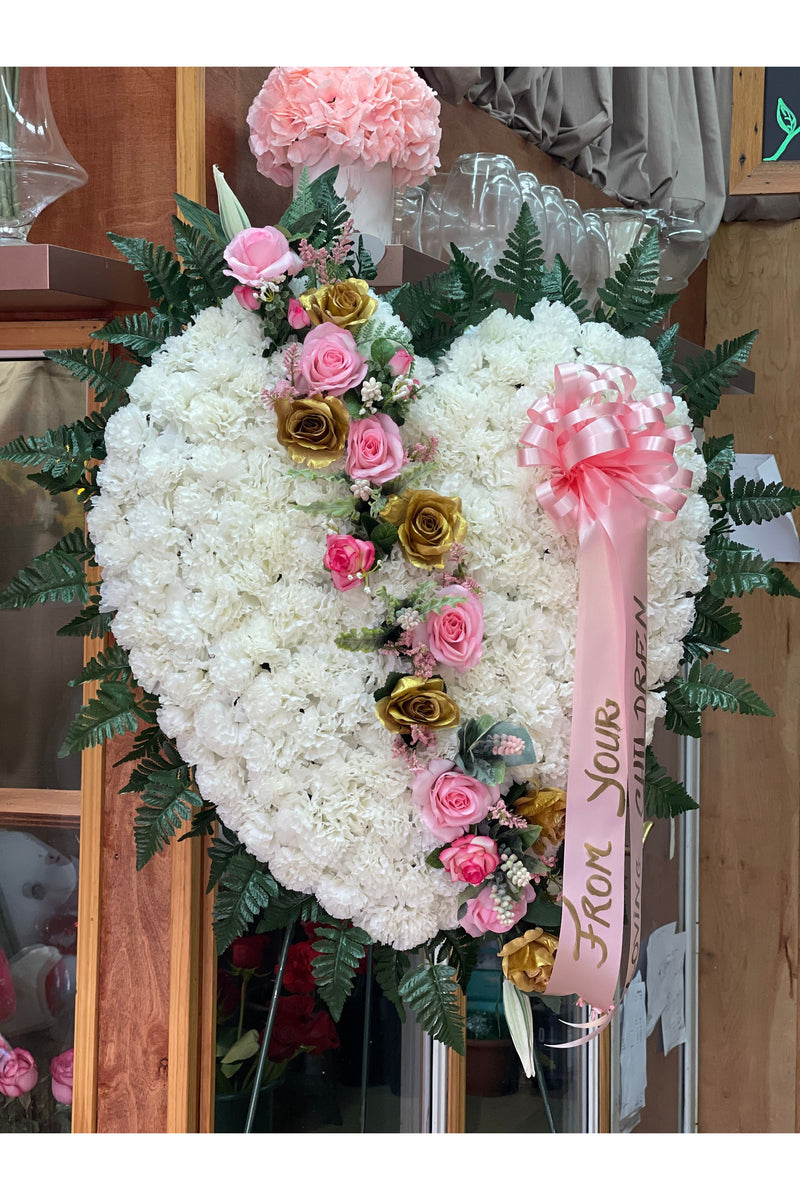 Artificial broken heart sympathy arrangement with white carnations, pink roses, and gold roses on easel stand by Eclore Floral NJ