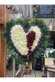 Purple, white, and red bleeding heart funeral standing spray with cascading red roses and purple outline.