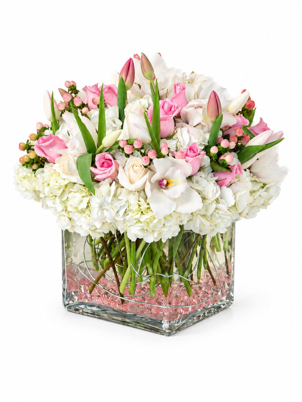 Blush Pearl pink roses, white hydrangeas and orchids in clear square glass vase for flower delivery