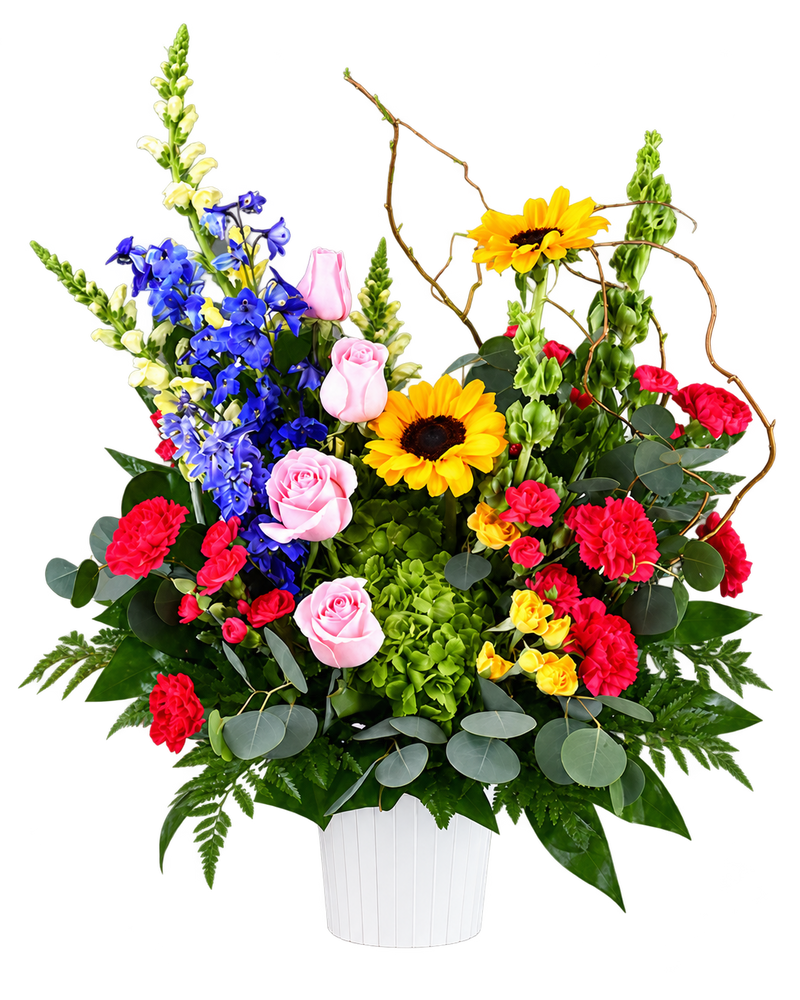 Colorful Remembrance Funeral Basket with sunflowers, pink roses, blue delphinium, red carnations and green hydrangea in a white container