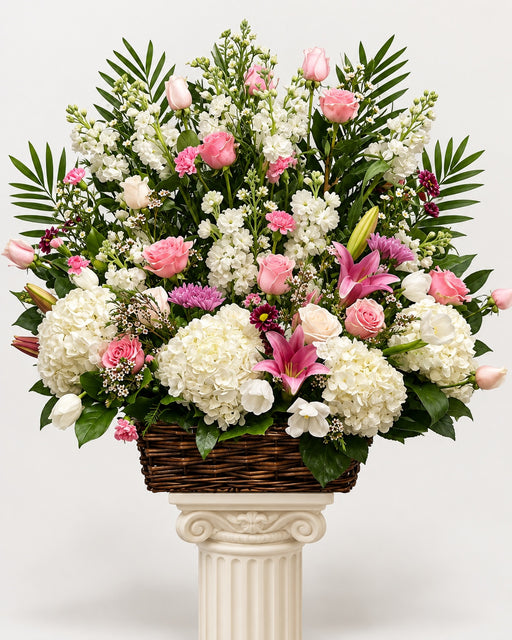 Blush Remembrance pink roses, lilies and white hydrangea sympathy basket without a picture frame on ivory pedestal