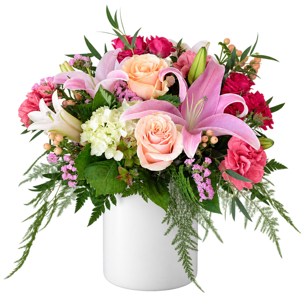 Pink lily and peach rose flower arrangement in a solid white ceramic vase