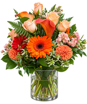 Rustic Flame orange flower arrangement with peach roses, orange gerbera daisies, calla lilies and dahlias in a clear glass vase