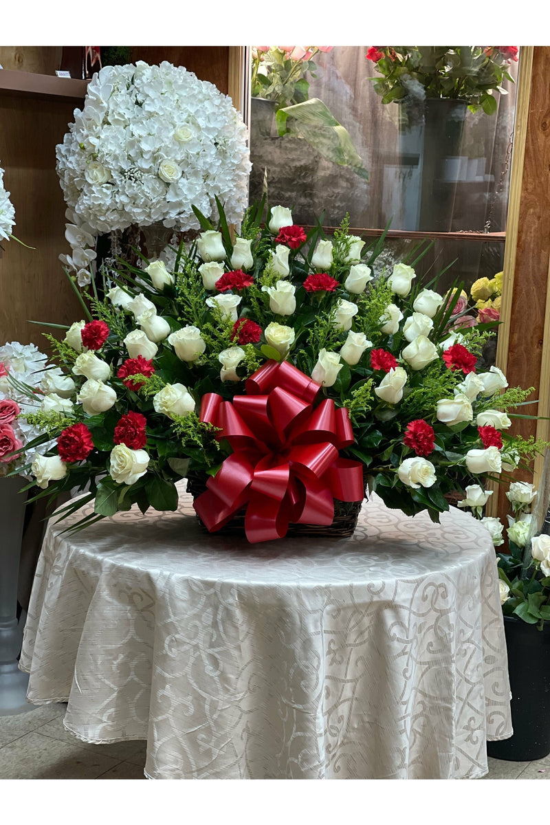 Red and white rose sympathy basket with carnations and a red satin bow — handcrafted by Eclore Floral in Hackensack, NJ