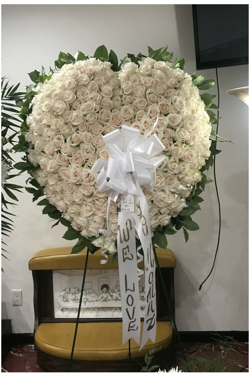 Full Rose Heart standing spray made of white roses with greenery on easel – funeral tribute arrangement