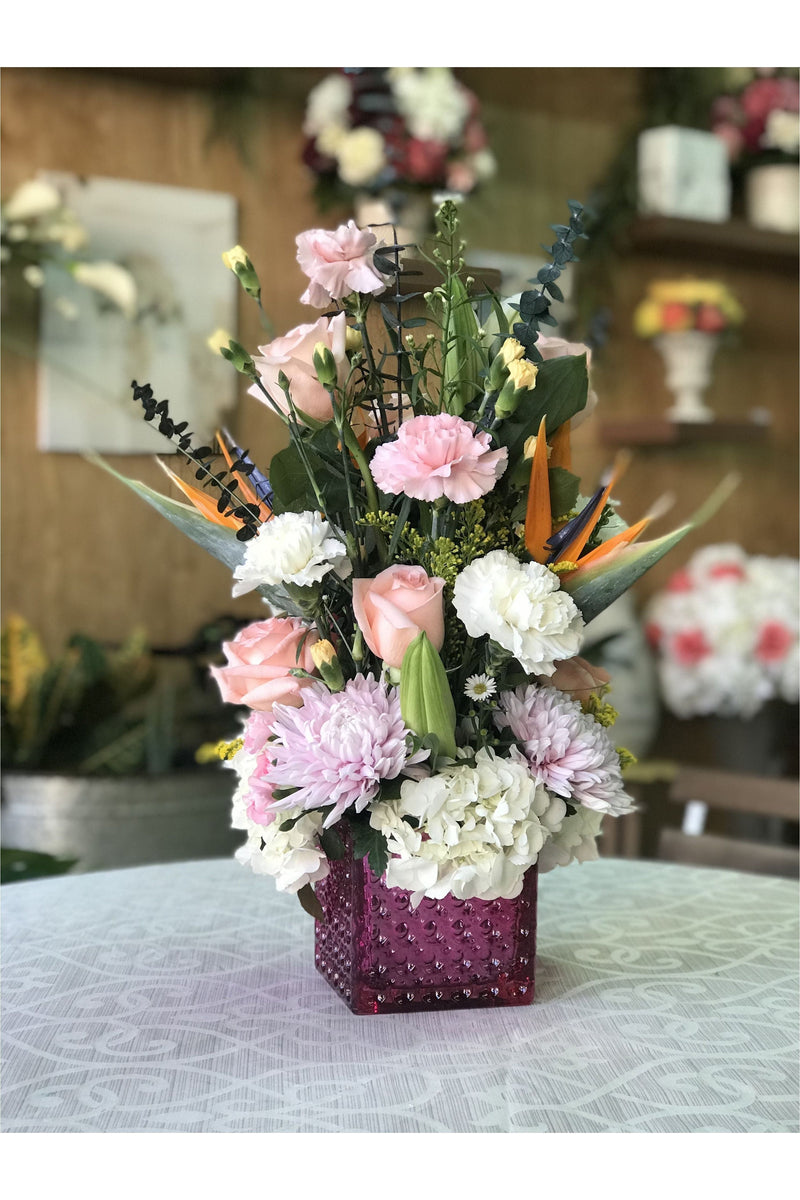 Pink berry floral arrangement with hydrangeas, roses, carnations, and Birds of Paradise in a pink vase – New Jersey florist.