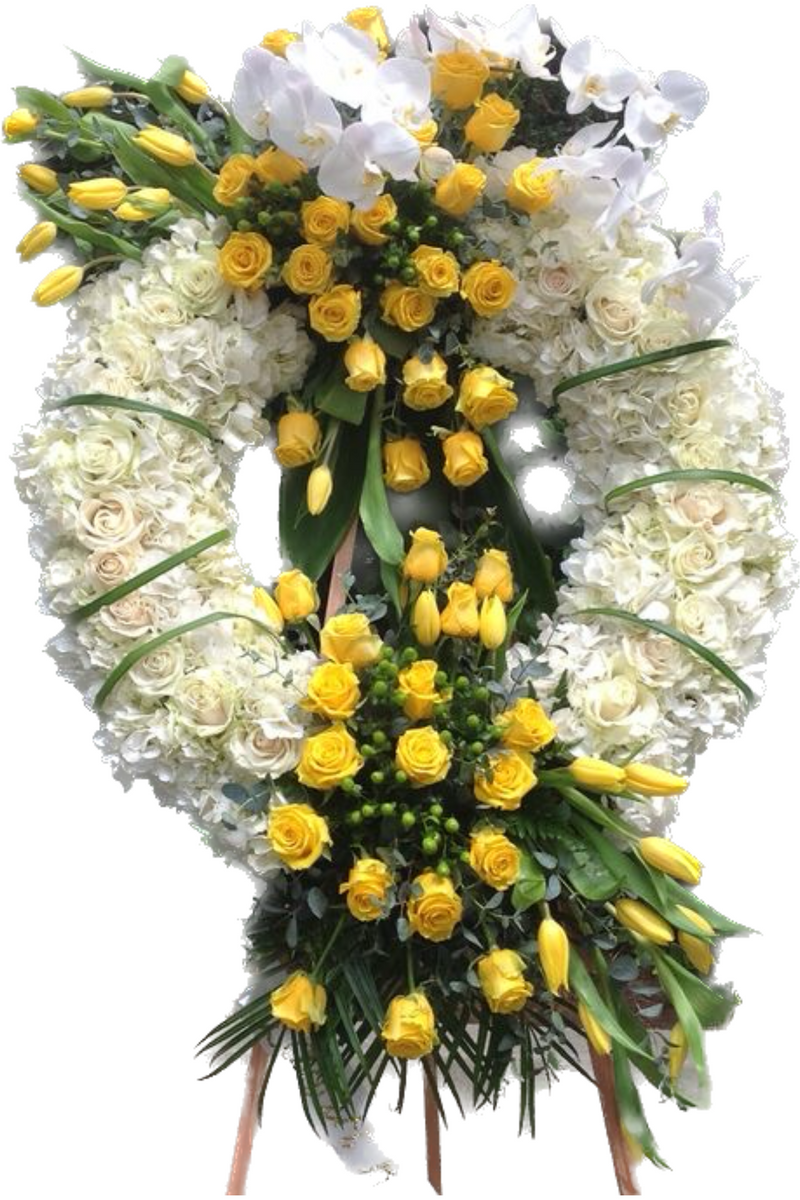 White hydrangea and yellow rose funeral wreath with orchids and tulips on standing easel – elegant sympathy tribute arrangement.