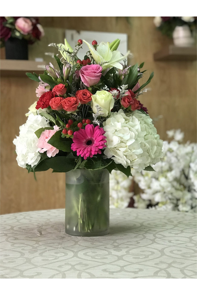 Vibrant gerbera daisy and hydrangea flower arrangement with roses and lilies in a frosted vase – New Jersey florist.
