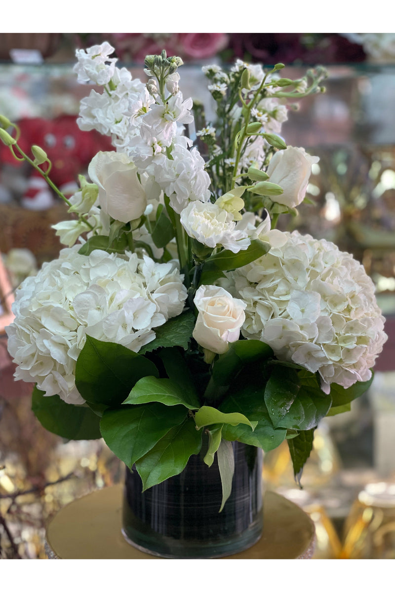Soft Harmony arrangement featuring white hydrangeas, roses, carnations, and stock flowers in a modern vase. Elegant all-white design by Eclore Floral with delivery in Hackensack, NJ.