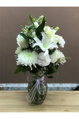 White roses, lilies, chrysanthemums, and carnations arranged in a clear vase by a New Jersey florist.
