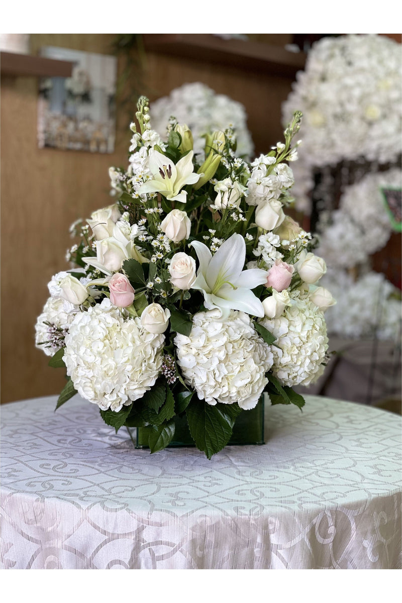 White sympathy flower arrangement with hydrangeas, lilies, and roses in a square vase – NJ delivery.