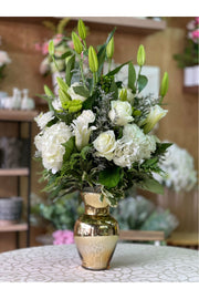 White Chocolate arrangement with white lilies, roses, hydrangeas, and greenery in a gold vase, handcrafted by Eclore Floral.