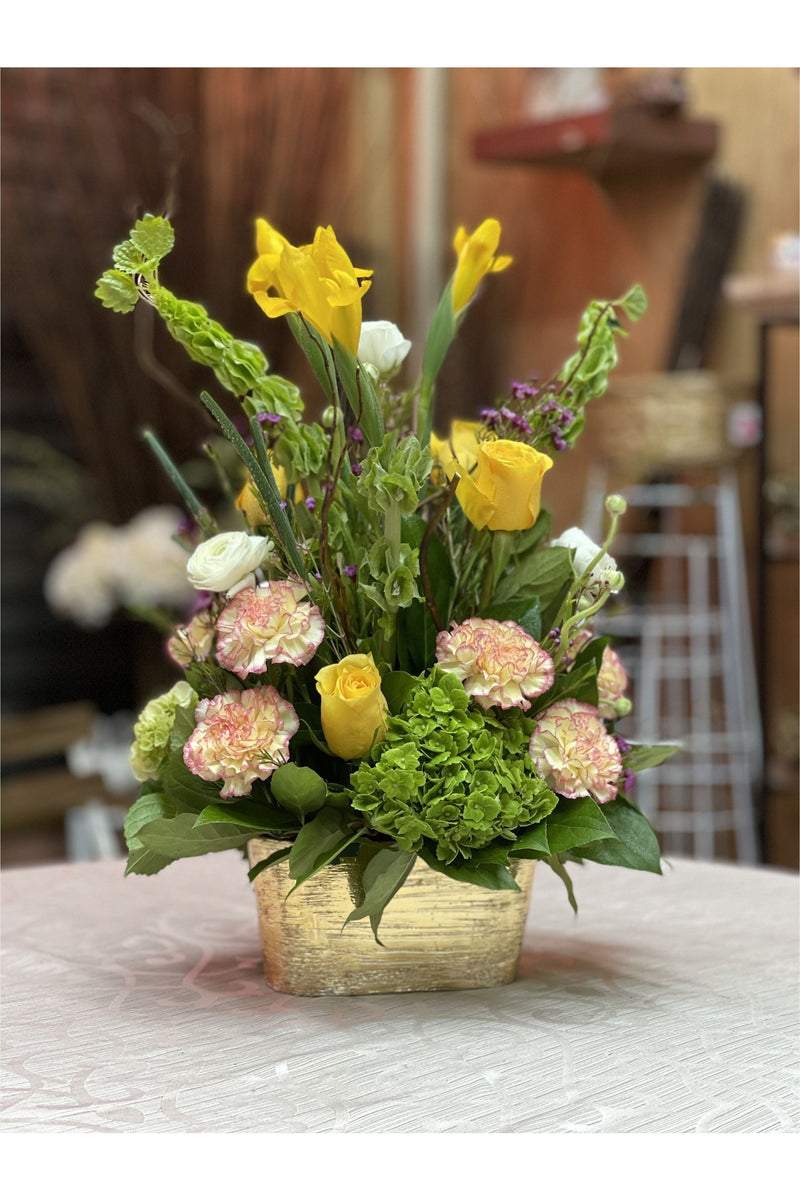 Yellow Crush floral arrangement with yellow roses, green hydrangeas, and pink carnations in a gold vase