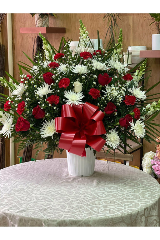 Red and white sympathy flower basket with roses, carnations, and white mums arranged by Eclore Floral in Hackensack, NJ