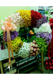 Multi-color funeral wreath with roses, chrysanthemums, and mixed blooms — handcrafted standing wreath for memorial and celebration-of-life services.