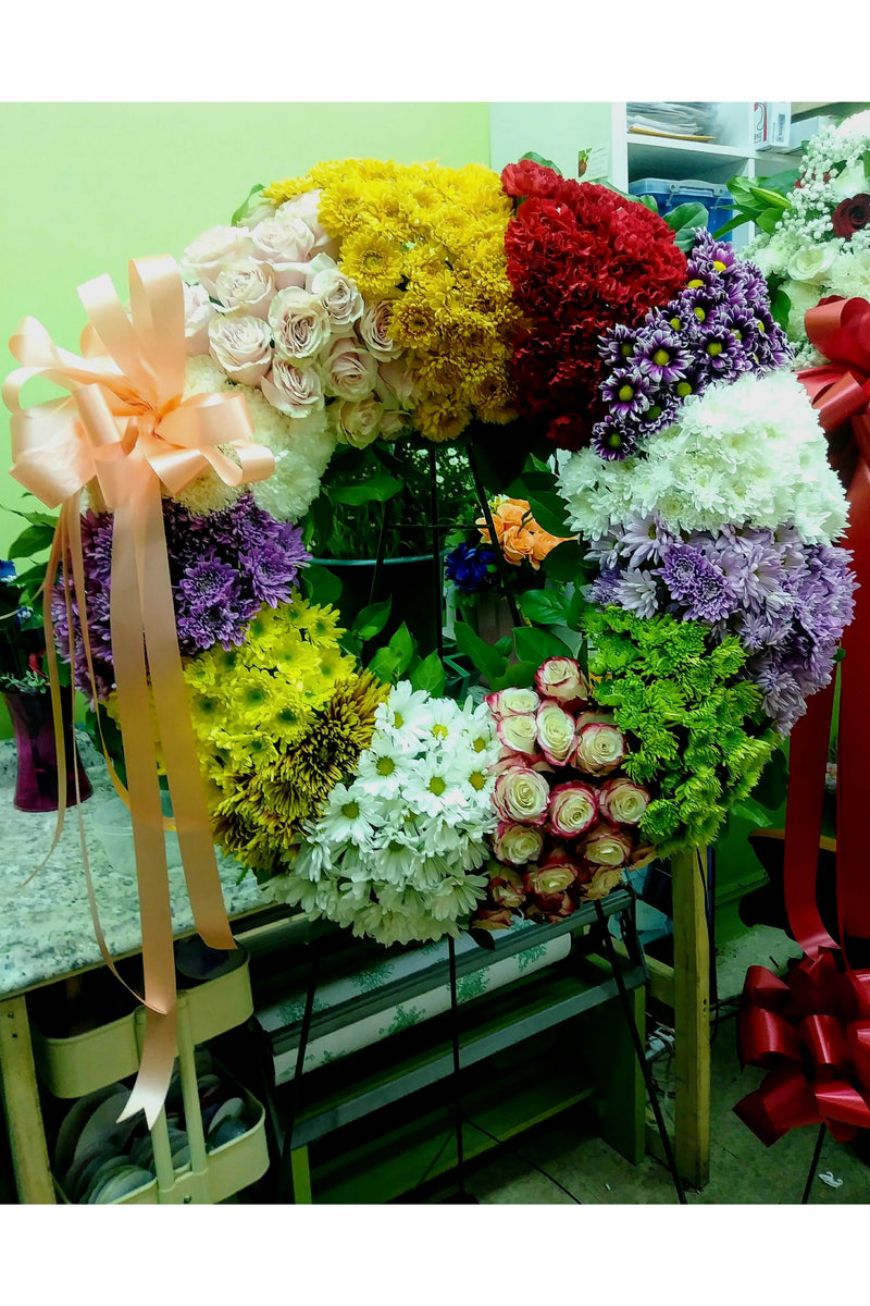 Multi-color funeral wreath with roses, chrysanthemums, and mixed blooms — handcrafted standing wreath for memorial and celebration-of-life services.